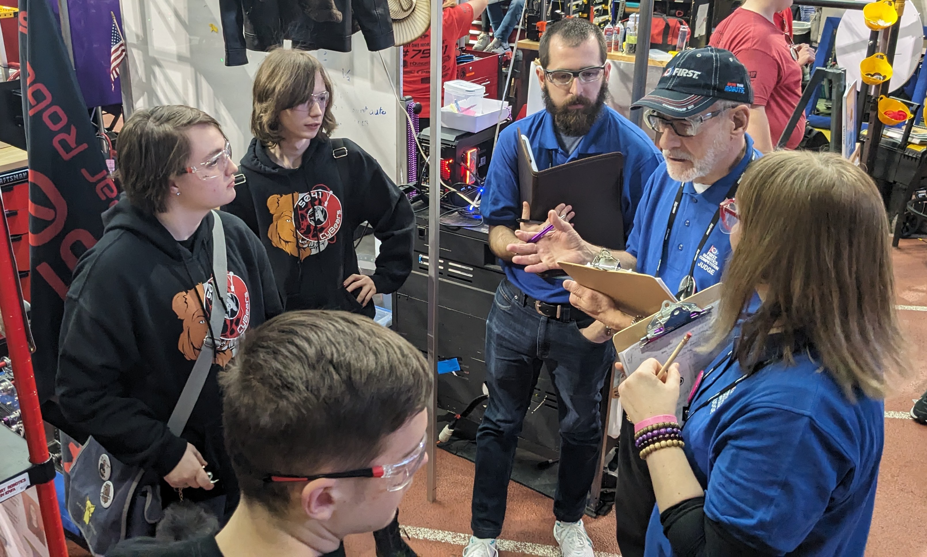 FRC judges talking with students in a pit area